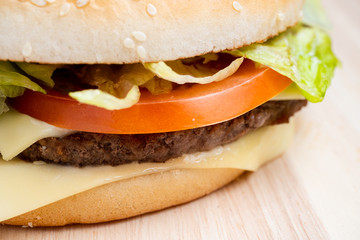Burger macro with side on a wooden background.