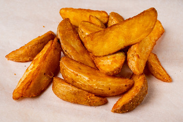 Rustic fried potatoes on a paper background.