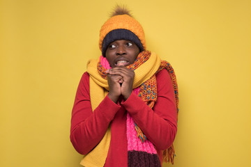 man in several hats and scarfs on yellow background.