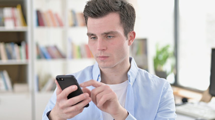 Young Student using Smartphone, Browsing Internet