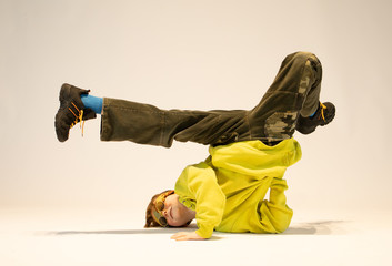 a boy in a unique dance figure, a small boy in a breakdance pose, an amazing boy in a crazy figure