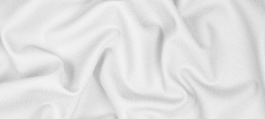 Obraz premium White woolen crumpled fabric with wrinkles and waves, closeup. Background, panorama or banner of crumpled tissue