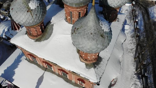 Slow cinematic flight by the Russian Church ("Church of the Resurrection on the Debra") in Kostroma on a clear winter day. View of the Church, bell tower, city and bridge across Volga river.