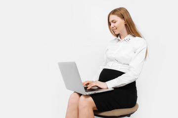Image of young pregnant businesswoman in glasses, girl working with laptop, sitting on chair