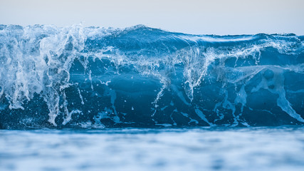 Clean and blue wave breaking in the ocean