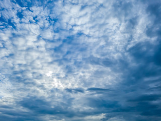 Fluffy white clouds in perspective in the blue sky.