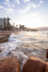 sunrise on the beach. beautiful summer scenery. rocks on the sand. calm waves on the water. clouds on the sky. wide panoramic view
