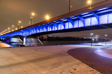 Modern illuminated bridge in Warsaw - capital of Poland. Boulevards on the Vistula river.