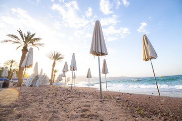 sunrise on the beach. beautiful summer scenery. rocks on the sand. calm waves on the water. clouds on the sky. wide panoramic view