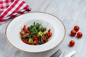 Warm fine dining salad with arugula, avocado and roasted beer stripes