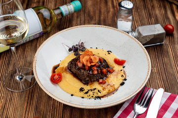 Slowly stewed veal cheeks with brown sauce and cheese polenta with parmesan
