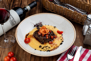 Slowly stewed veal cheeks with brown sauce and cheese polenta with parmesan