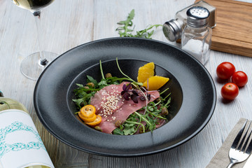 Parma ham salad with capers, arugula and orange