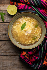 Mexican corn grain boiled also called esquites with cheese and mayonnaise on wooden background