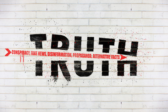The word truth with an arrow of conspiracy, fake news, disinformation, propaganda, alternative facts, painted on old white wall, Truth being destroyed concept illustration