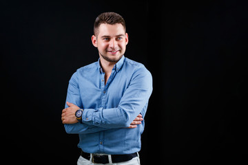 Fellow businessman in blue shirt and white trousers on a black background
