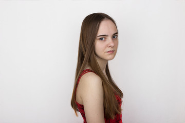 a beautiful young girl of eighteen (18 years old) with long blond hair, gray eyes, wide black eyebrows, without makeup, without makeup, in a red checkered dress on sleeveless britches. Waist-length po