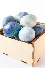 Easter eggs. Colored and decorated Easter Eggs  in a wooden box on white background. Easter pattern. Dyed holiday eggs.