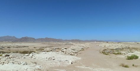 Desert landscape with rocky mountains without people. Sea resort on the desert coast