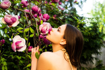 Fototapeta premium Beauty spring girl with magnolia Flovers. Tenderness sensual woman. Passion and sensual touch.