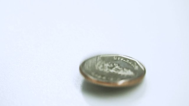 Thai Baht currency money coin spin and stop on white background table. Background concept for Thailand economy.