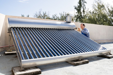 Male Plumber Repairing Solar Energy Boiler