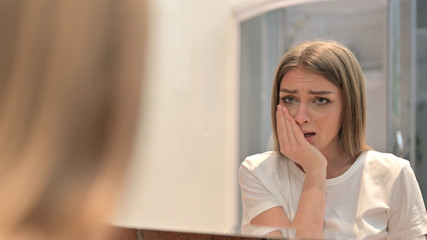 Rear View of Upset Young Woman Crying in the Mirror
