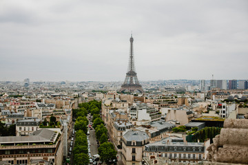 Top view on streets of Paris, buildings, roads with traffic and Eiffel tower 