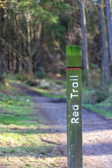 Red trail signpost next to path in Tyrebagger forest