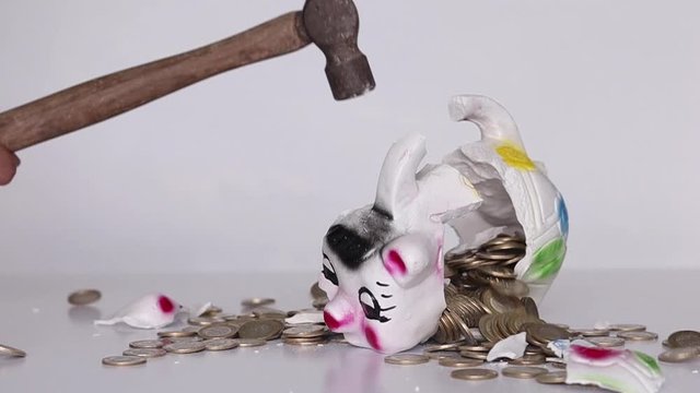 Breaking piggy bank with a hammer