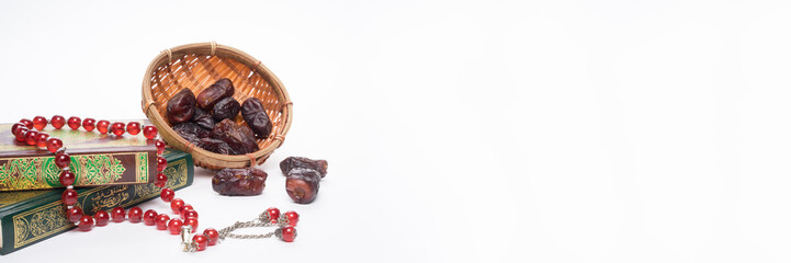 Faith in Islam concept. The Islamic holy book, Quran or Kuran, with rosary beads or “tasbih” isolated on white background. Panoramic or banner format