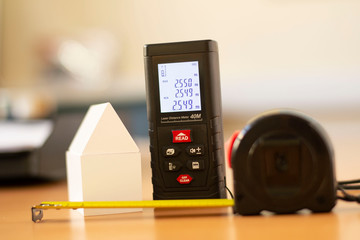 length measuring instrument, laser meter, meter, ruler, white model of house