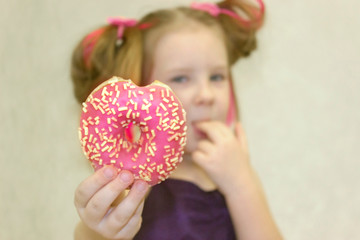 The child put forward a hand with a donut.