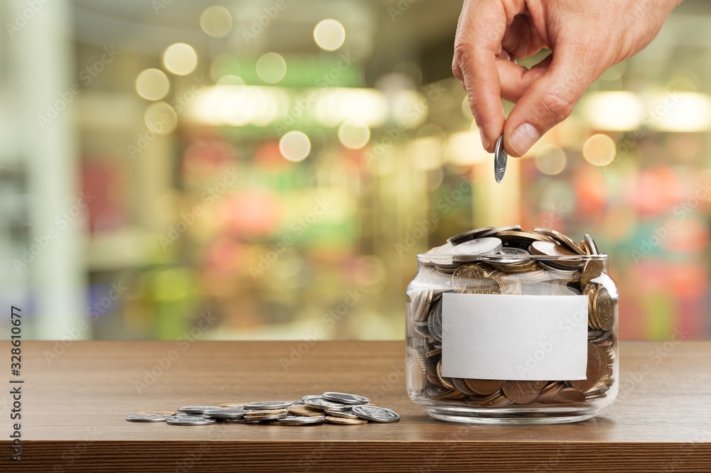 Sticker Hand putting coins in a glass jar with a blank label