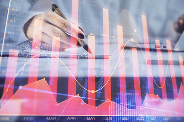 Double exposure of woman's hands making notes with forex graph hologram. Concept technical analysis.