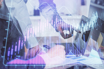 Double exposure of graph with man typing on computer in office on background. Concept of hard work. Closeup.