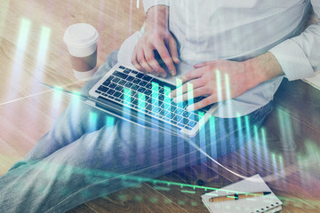 Forex graph with businessman working on computer in office on background. Concept of analysis. Double exposure.