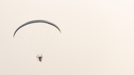 Pilots riding on a paramotor gliding in the sky