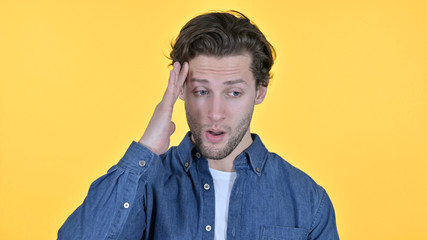 Fototapeta premium Young Man Having Headache, Pain in Head on Yellow Background