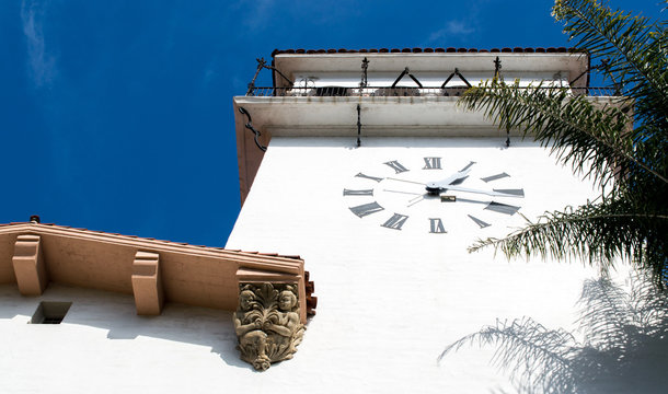 El Mirador clock tower at the historic Santa Barbara County courthouse in California surrounded by palm trees under blue sky