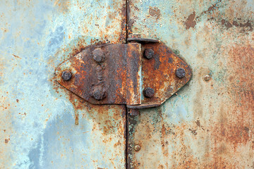 Rusty hinge on old rusted iron door, close-up