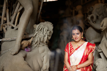 Portrait of an young and beautiful Indian Bengali brunette woman in red and white traditional...