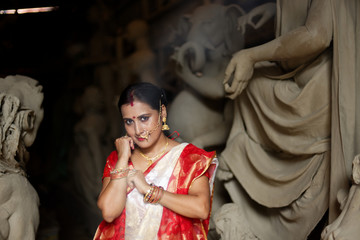 Portrait of an young and beautiful Indian Bengali brunette woman in red and white traditional...