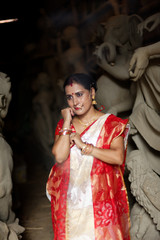 Portrait of an young and beautiful Indian Bengali brunette woman in red and white traditional...