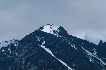 Mountain range under cloudy sky. Snowy peaks of mountains rocks