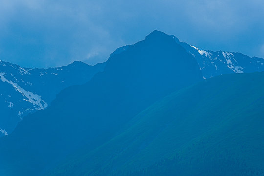 high cliffs in blue haze, silhouette of mountain range in fog, meditation and relaxation in nature