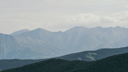 silhouette of mountain range in haze on horizon in mountain valley. Hiking in wild