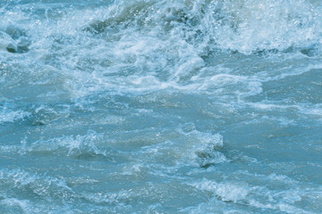 Fototapeta na wymiar rushing water of fast flowing river, storm waves of ocean, sea surf