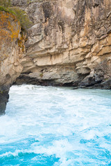 blue seething water beats against rocks, sea surf, rapid flow of  mountain river, ocean waves of tide