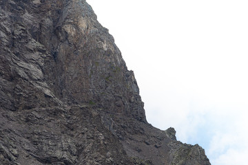 rock cliff against sky. Travel in mountains, stone wall for mountaineering
